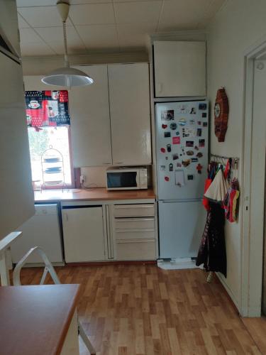 a kitchen with white cabinets and a white refrigerator at Nina`s GuestHouse, Jämsä City, 160 m2, Include x2 Himos Ski Pass in Jämsä
