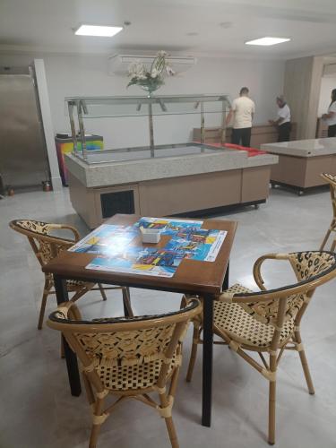 einen Tisch und Stühle in einem Zimmer mit Waschbecken in der Unterkunft Com CAFE SPAZZIO DIROMA e ACESSO ao ACQUA Parque DIROMA TODOS OS DIAS in Caldas Novas