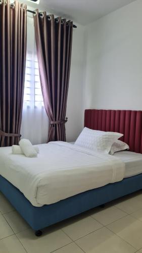 a large bed with a red headboard and curtains at Alanis Suite KLIA With Neflix & Airport Shuttle in Sepang