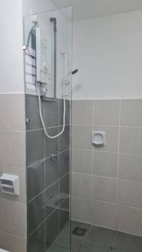 y baño con ducha y puerta de cristal. en Alanis Suite KLIA With Neflix & Airport Shuttle, en Sepang