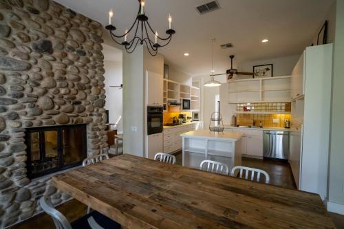 a kitchen with a wooden table and a stone wall at Sage Hill Inn & Spa in Kyle