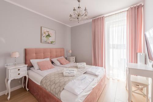 - une chambre avec un lit, un bureau et une fenêtre dans l'établissement Posesja Kapitańska Apartament ok 100 m do plaży, à Grzybowo