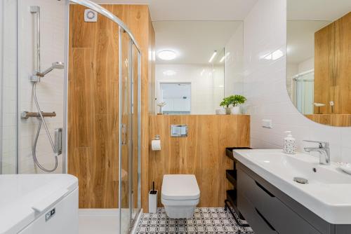 La salle de bains est pourvue d'une douche, de toilettes et d'un lavabo. dans l'établissement Posesja Kapitańska Apartament ok 100 m do plaży, à Grzybowo