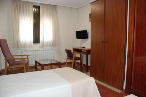 ein Hotelzimmer mit einem Bett, einem Tisch und Stühlen in der Unterkunft Apartahotel FC Catedral in León