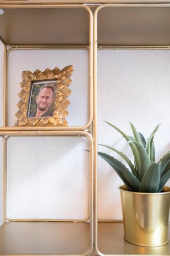 a framed picture of a man next to a potted plant at Les Figuiers - Appartement 2 Chambres avec Sauna à Andenne in Andenne