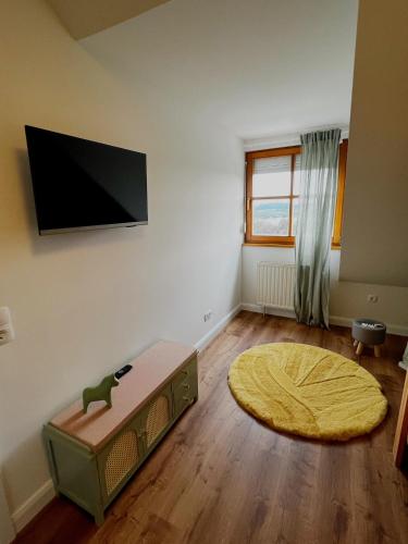 a living room with a flat screen tv on a wall at Seehotel Losheim in Losheim