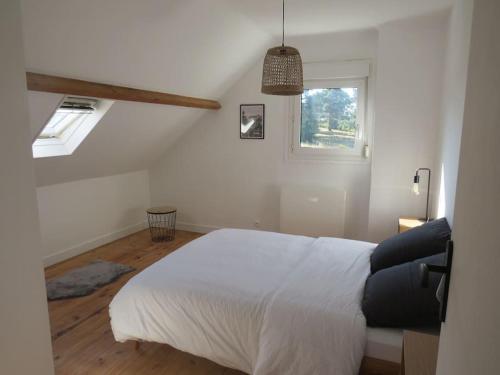a bedroom with a white bed and a window at Maison - plage à pied in Frehel