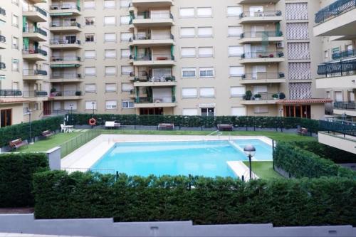 a large swimming pool in front of a building at Amplio apartamento con piscina al lado de la playa in Platja d'Aro