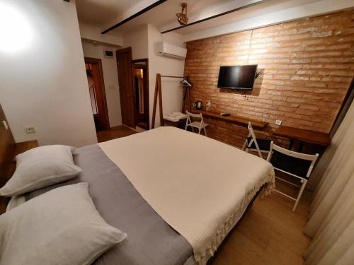 a bedroom with a large bed and a brick wall at Fanus Suites Karaköy in Istanbul