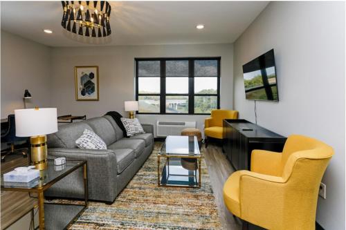 a living room with a gray couch and yellow chairs at Fairway in Altoona