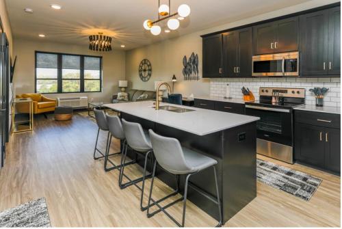 a kitchen with black cabinets and a kitchen island with bar chairs at Fairway in Altoona