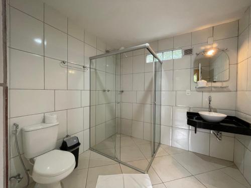 a bathroom with a shower and a toilet and a sink at Flat Salto D'Água in Penedo