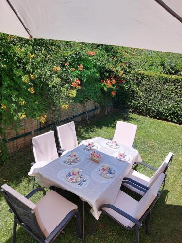 a table and chairs under an umbrella in a yard at Luxury VILLA LE ROSE in Poreč
