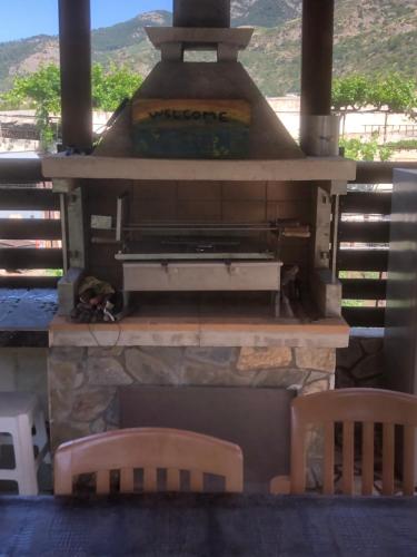 an outdoor pizza oven with two chairs and a table at DIAMOND Stone Wooden Guest House in Khandria