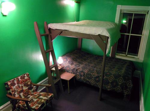a green room with a bunk bed and a chair at The Arlington in Maynooth
