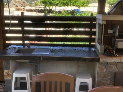 a kitchen with a sink and a counter with chairs at DIAMOND Stone Wooden Guest House in Khandria