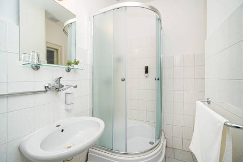 ein Bad mit einer Glasdusche und einem Waschbecken in der Unterkunft Compact Apartment Sleeps 6 + Great Location in Prag
