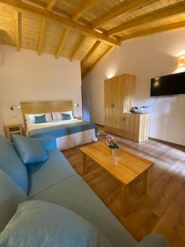 Habitación con cama, sofá y mesa. en Villa Marín Toledo, en Las Nieves