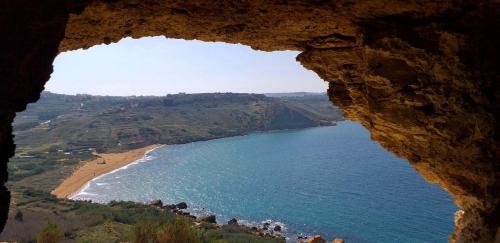 a view of a beach from a rock cliff at MJ Farmhouse B&B in Xagħra