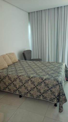 a bedroom with a bed with a patterned blanket on it at Casa Duplex - Garanhuns in Garanhuns