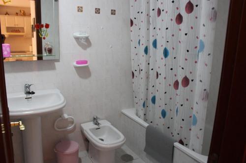 a bathroom with a sink and a toilet and a shower curtain at VV El Médano Sur in El Médano