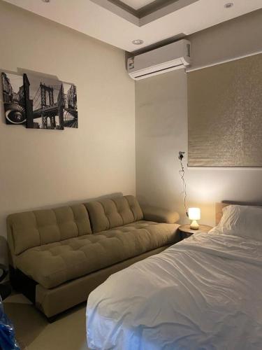 - un salon avec un canapé et un lit dans l'établissement شقة مدخل خاص دخول ذاتي, à Riyad