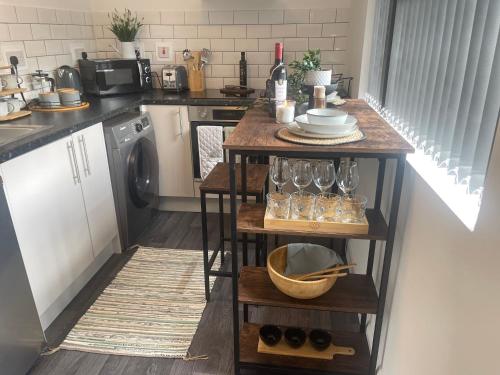 a kitchen with a table with wine glasses on it at Cute+Cozy Guesthouse for 2 +secure offroad parking in Fallings Park