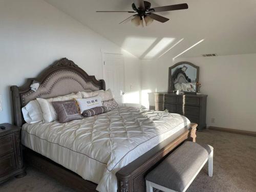 a bedroom with a large bed and a ceiling fan at Amazing Lakefront Home with a Private Beach in Lake Elsinore