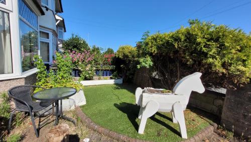 a small garden with a white horse chair and a table at Mill Lane in Wallasey