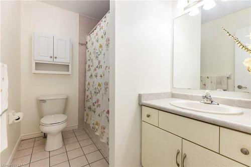 a white bathroom with a toilet and a sink at Aiden Mansion in London