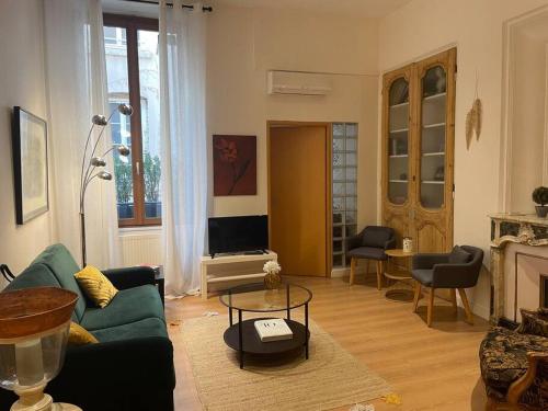 a living room with a green couch and a fireplace at Plein centre de Lyon ! Chic et pratique! in Lyon