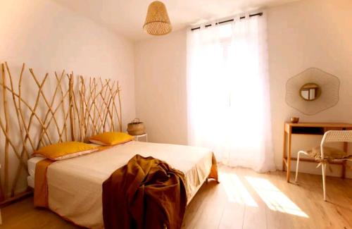 - une chambre avec un lit doté d'oreillers jaunes et d'une fenêtre dans l'établissement Appartement 72m2 cosy centre ville, à Saint-Rémy-de-Provence