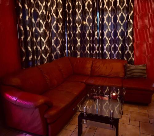 a brown leather couch in a room with a fireplace at Velvet Motel in Hegyeshalom