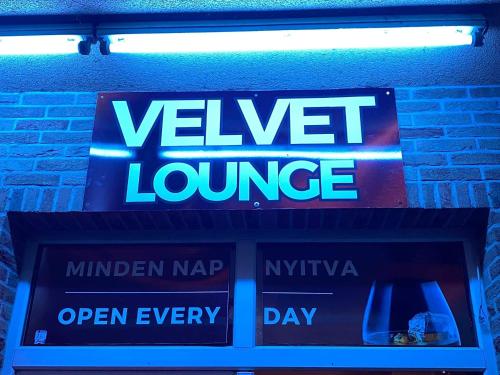 a sign for avallele lounge on a brick wall at Velvet Motel in Hegyeshalom