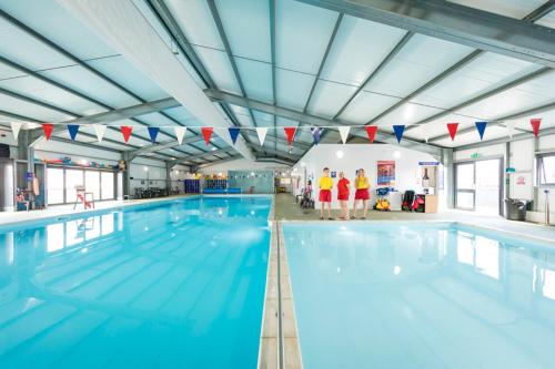 une grande piscine avec des personnes debout à côté de celle-ci dans l'établissement A&A Caravan Holidays, à Leysdown-on-Sea
