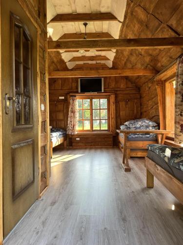 pokój z 2 łóżkami w drewnianym domku w obiekcie Domki wędkarskie nad Stawami Pirania w mieście Zagórz