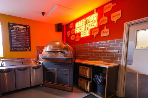 a fast food restaurant kitchen with an orange wall at A&A Caravan Holidays in Leysdown-on-Sea