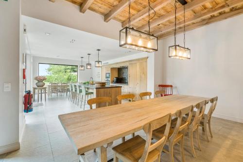 a kitchen and dining room with a wooden table and chairs at VAKANTIEWONING HUYZE ANNE MARIA in Damme