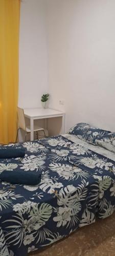 une chambre avec un lit avec une couverture bleue et blanche dans l'établissement LA MARINA, à Alicante