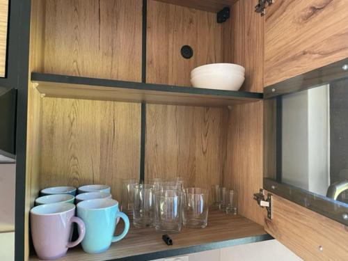 a wooden cabinet with glasses and mugs on it at Świerkowy Zakatek in Idzików