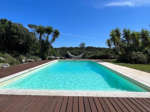 a swimming pool with blue water in a yard at Quinta do espelho d'agua, Estudio in Reguengo Grande