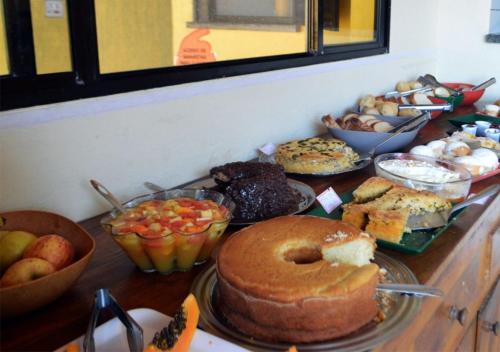 a table topped with lots of different types of food at Pousada Casa na Praia in Ubatuba