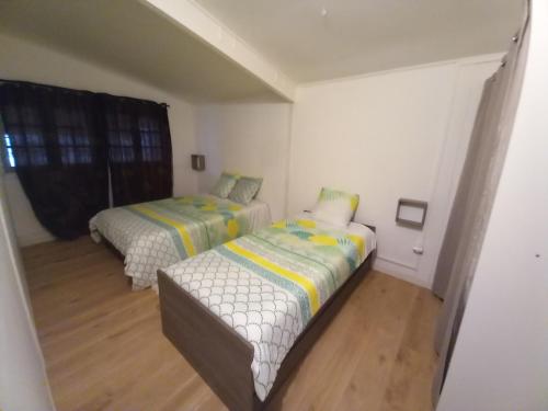 1 dormitorio con 2 camas y sofá en Eskal des berges, en Bras-Panon