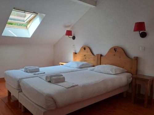 un par de camas en un dormitorio con ventana en Duplex-Chalet entre Lac et Montagne - Balcon Vue Lac, en Lugrin