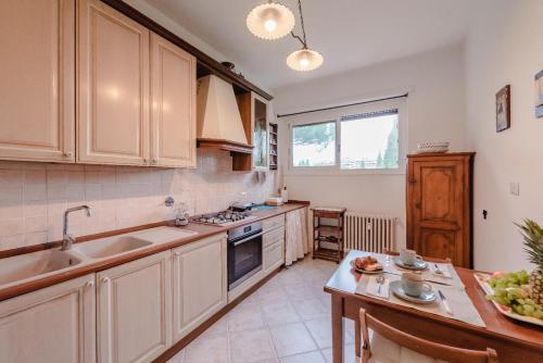 a kitchen with white cabinets and a sink and a table at RESIDENZA ERES EUR in Rome