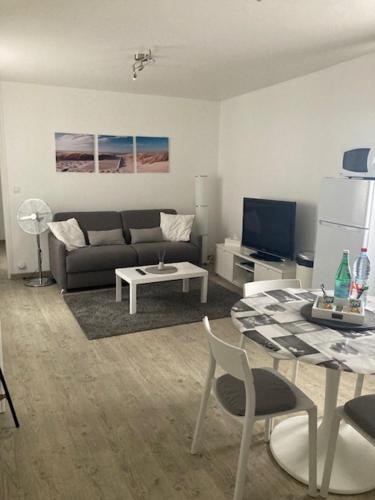 sala de estar con sofá y mesa en Appartement proche Mer en Berck-sur-Mer
