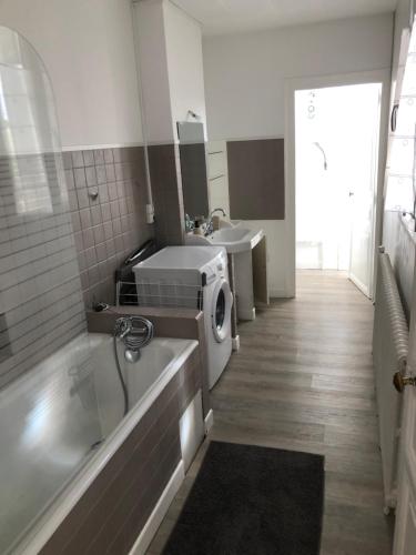 une salle de bain avec baignoire et machine à laver dans l'établissement Grand Appartement Privatif, à Châteauroux