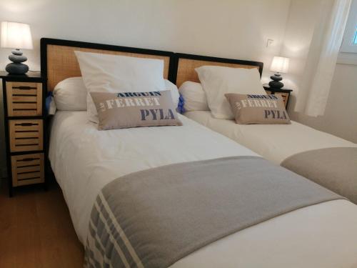 2 camas en un dormitorio con 2 almohadas en Le Pacha, en Andernos-les-Bains