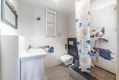 a white bathroom with a toilet and a sink at SŁONECZNIK in Ostrowo