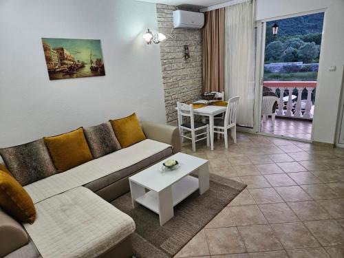 a living room with a couch and a table at Apartments FLORA and boat cruising in Virpazar